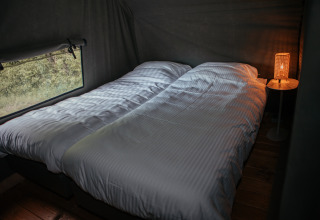 Dos camas individuales en una Waterlodge en Recreatiepark De Achterste Hoef, Países Bajos, con lámpara.