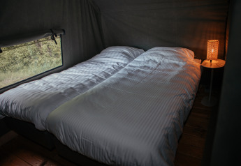 Deux lits simples dans une Waterlodge au Recreatiepark De Achterste Hoef, Pays-Bas, avec lampe allumée.