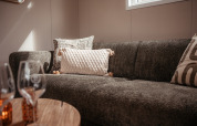 Knusse zithoek in een luxe chalet op Recreatiepark De Achterste Hoef in Nederland, met zachte kussens.
