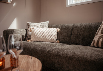 Gezellige zithoek in een luxe chalet bij Recreatiepark De Achterste Hoef in Nederland, met sierkussens.