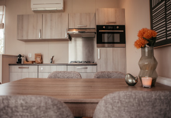 Cocina moderna y comedor en un chalé de lujo en Recreatiepark De Achterste Hoef, Países Bajos.