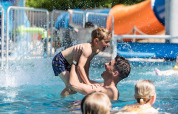 Vater und Sohn spielen im Pool im Kampeerdorp de Zandstuve, einem Ferienpark in Overijssel, Niederlande.