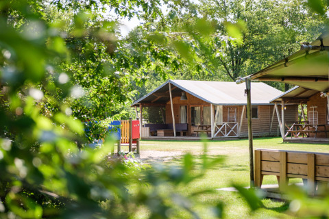 Houten huisjes in het groen bij Kampeerdorp de Zandstuve, een vakantiepark in Overijssel, Nederland.