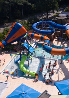 Luftaufnahme eines Wasserparks mit bunten Rutschen und Pools im Kampeerdorp de Zandstuve in Overijssel.
