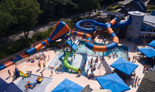 Vista aérea del parque acuático en Kampeerdorp de Zandstuve con toboganes y piscinas en Overijssel, Países Bajos.