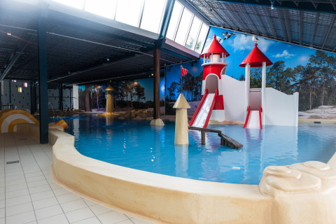 Indendørs vandland med rutsjebaneborg og pools i Kampeerdorp de Zandstuve feriepark, Overijssel, Holland.