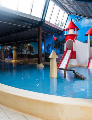 Zona de juegos acuáticos cubierta con toboganes en Kampeerdorp de Zandstuve, parque vacacional en Overijssel, Países Bajos.