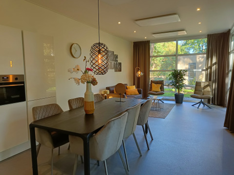 Moderna cabaña L-Cube 4+2 en De Utrechtse Heuvelrug, Países Bajos, con sala y comedor elegantes.