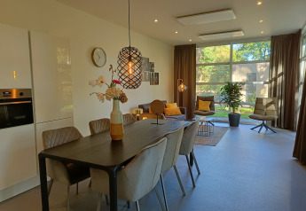 Moderna cabaña L-Cube 4+2 en De Utrechtse Heuvelrug, Países Bajos, con sala y comedor elegantes.