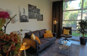 Moderne woonkamer in L-Cube 4+2 lodge bij De Utrechtse Heuvelrug, Nederland, met grote ramen en stijlvol interieur.