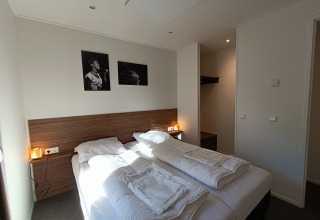 Moderne lodge-slaapkamer in L-Cube 4+2 aan De Utrechtse Heuvelrug, Nederland, met twee aparte bedden.