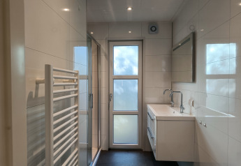 Moderne, lichte badkamer in L-Cube 4+2 lodge bij De Utrechtse Heuvelrug, Nederland, met glazen douche.