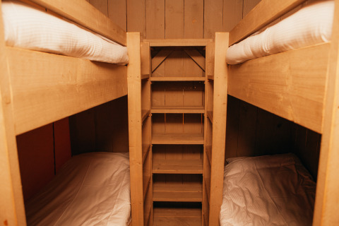 Wooden bunk beds with ladders inside a Safari Tent at Holiday Park De Boshoek, Netherlands, cozy setup.