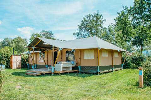 Safari Villa Zeltunterkunft im Ferienpark De Boshoek, Niederlande, im sonnigen, grünen Gelände.