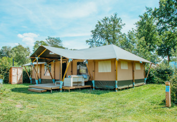 Hébergement en tente Safari Villa au Holiday park De Boshoek, Pays-Bas, dans un espace vert ensoleillé.