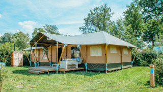 Alojamiento en tienda Safari Villa en Holiday park De Boshoek, Países Bajos, rodeado de césped verde.