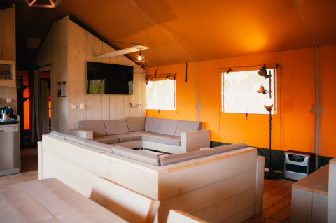Innenraum eines Safari-Zeltes mit modernen Möbeln und Fernseher im Holiday Park De Boshoek, Niederlande.