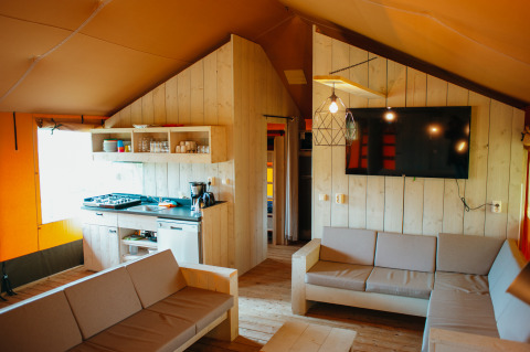 Interieur van de Safari Villa safaritent met keuken en zithoek bij Holiday park De Boshoek, Nederland.