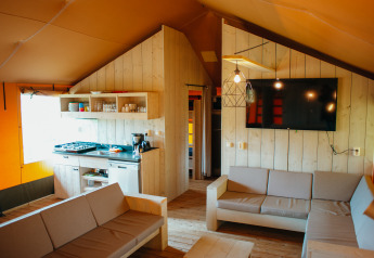 Interior view of the Safari Villa tent with kitchen and lounge at Holiday park De Boshoek, Netherlands.