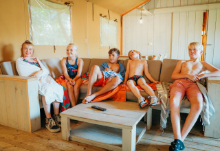 Kinder entspannen sich auf einem Sofa im Safari-Zelt der Ferienanlage De Boshoek in den Niederlanden.