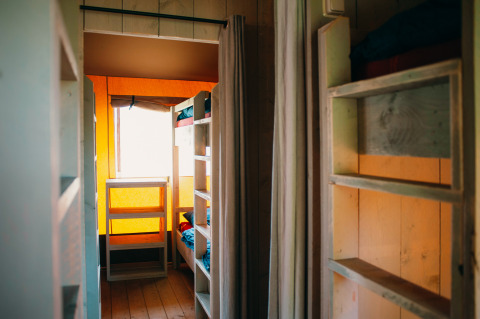 Binnenaanzicht van de Safari Villa tent bij vakantiepark De Boshoek in Nederland met houten stapelbedden.