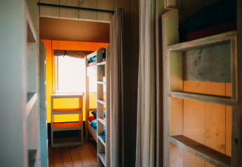 Interior view of Safari Villa tent at Holiday park De Boshoek in the Netherlands with bunk beds and wood.