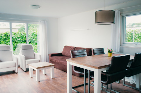 Modernes Wohnzimmer in der Veluwelodge im Ferienpark De Boshoek, Niederlande, mit hellem Interieur.