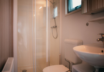 Moderne badeværelse med brusekabine, toilet og håndvask i Veluwelodge ved Holiday park De Boshoek, Nederlandene.