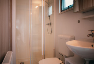 Modernes Badezimmer mit Dusche, WC und Waschbecken in der Veluwelodge im Holiday park De Boshoek, Niederlande.