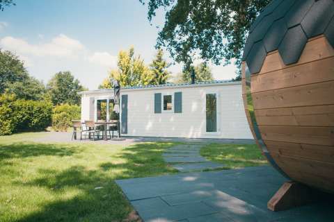 Buitenaanzicht van Veluwe lodge met sauna aan Holiday park De Boshoek, Nederland, met tuin en terras.