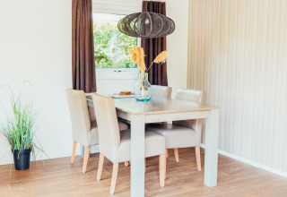 Luminoso comedor en Veluwe lodge + sauna en Holiday park De Boshoek, Países Bajos, con muebles modernos.