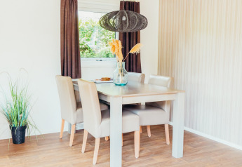 Lyst spisestueområde i Veluwe lodge + sauna ved Holiday park De Boshoek, Nederlandene med moderne møbler.