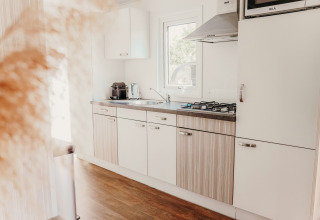 Cocina moderna y luminosa en una Veluwe lodge, con suelo de madera y estufa de gas en De Boshoek, Países Bajos.