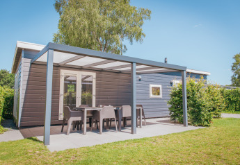 Moderne Veluwelodge XL im Ferienpark De Boshoek in den Niederlanden mit überdachter Terrasse und Gartenmöbeln