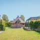 Foto van een houten lodge en groen bij Veluwelodge XL, vakantiepark De Boshoek, Nederland.