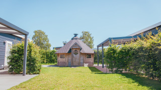 Foto von einer Holzhütte und Garten bei Veluwelodge XL im Ferienpark De Boshoek in den Niederlanden.