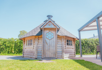 Foto de Veluwelodge XL en Holiday park De Boshoek en los Países Bajos, una acogedora cabaña de madera al sol.