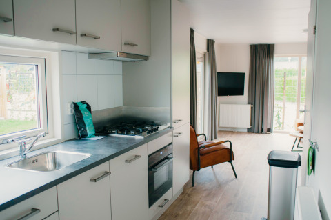 Moderne keuken en woonkamer in Veluwelodge XL op Holiday park De Boshoek, Nederland, met lichte inrichting.