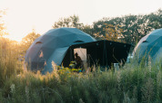 Rund Holly-telt på Holiday Park Sallandshoeve i Holland, omgivet af natur og græs ved solnedgang.