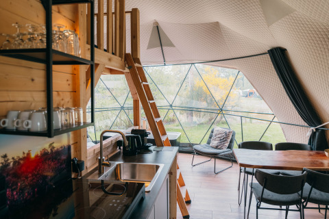 Intérieur du Round Holly Tent au Holiday Park Sallandshoeve, décor moderne et grandes fenêtres sur la nature.