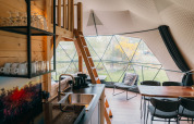 Intérieur du Round Holly Tent au Holiday Park Sallandshoeve, décor moderne et grandes fenêtres sur la nature.