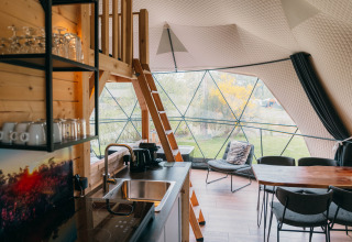 Intérieur du Round Holly Tent au Holiday Park Sallandshoeve, décor moderne et grandes fenêtres sur la nature.