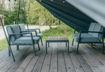 Zona salotto esterna presso Round Holly Tent al Holiday Park Sallandshoeve nei Paesi Bassi, con sedie e tavolo.