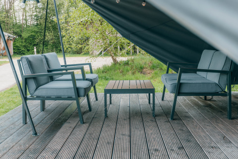 Udendørs siddeområde ved Round Holly Tent på Holiday Park Sallandshoeve i Holland med stole og bord.