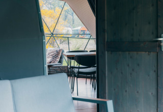 Uitzicht door een open deur op een zitruimte in de Round Holly Tent bij Holiday Park Sallandshoeve, Nederland.