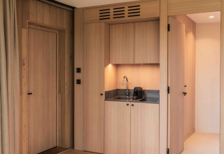 Moderna cocina pequeña con paneles de madera en la Lumni Pod tiny house en Wilsumer Berge, Alemania.