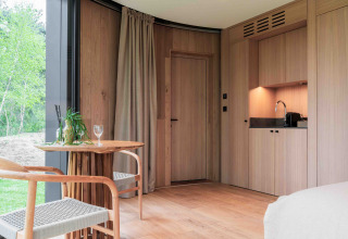 Interior moderno de madera en Lumni Pod en Wilsumer Berge, Alemania, con zona de cocina y comedor.