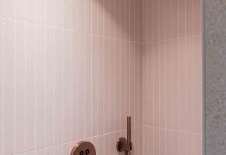 Ducha moderna en Lumni Pod, Wilsumer Berge, Alemania, con azulejos beige y grifería de latón elegante.
