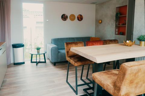 Familienlodge im Holiday Park De Boshoek, Niederlande, mit modernem Wohn- und Essbereich, gemütlich eingerichtet.