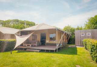 Tienda Safari cottage en Holiday park De Boshoek, Países Bajos, con terraza y zona de estar exterior.